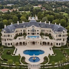 an aerial view of a large mansion with a pool in the middle and trees surrounding it