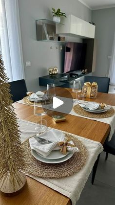 a dining room table set for christmas with place settings and silverware on the plates