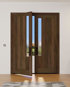 an open wooden door in a room with wood flooring and rug on the floor