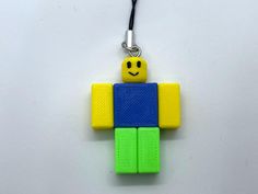 a lego keychain with a smiley face on it's chest and arms