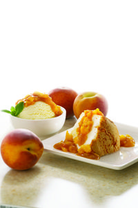 a plate topped with cake next to peaches and ice cream on top of a counter