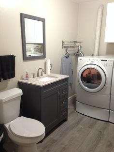 a washer dryer sitting next to a toilet and sink in a small bathroom