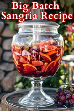 a big batch sangria recipe in a glass jar on top of a wooden barrel