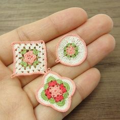 three crocheted pieces are shown in the palm of a person's hand