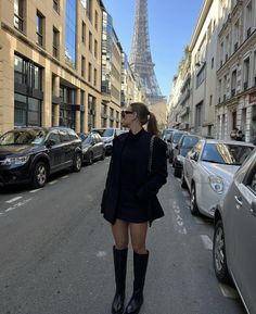 a woman walking down the street wearing boots