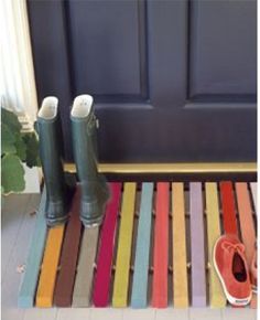 a pair of rain boots sitting on top of a colorful mat in front of a door