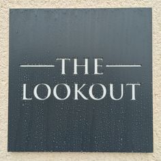 the lookout sign is displayed in front of a building with rain drops on it