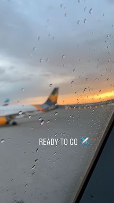 an airplane is on the tarmac with rain drops