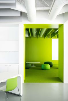 an office with green walls and white furniture