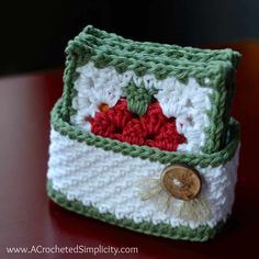 a small crocheted purse sitting on top of a red table next to a wooden button