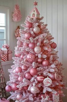 a pink christmas tree decorated with ornaments