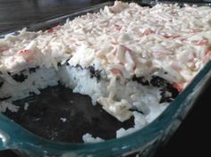 a cake with white and red toppings in a glass dish