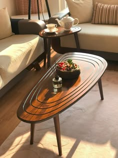 a wooden table sitting on top of a hard wood floor next to a white couch