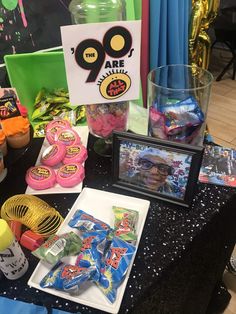 a table topped with candy and candies on top of a black tablecloth covered table