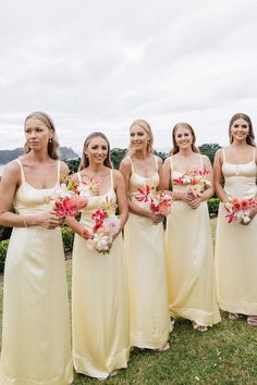 a group of women standing next to each other on top of a lush green field