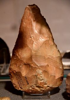 a piece of rock sitting on top of a table next to other rocks and stones