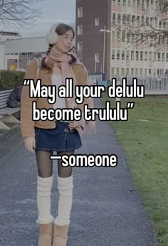 a woman standing on top of a sidewalk next to a grass covered field with the words, may all your delu become trul someone