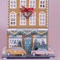 a christmas card with two cars parked in front of a building that says anthropologie