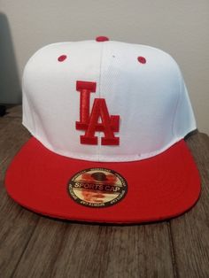 New white and red LA 6 panel snapback White Flat Bill Trucker Hat For Baseball Season, Red Six-panel Fitted Hat For Streetwear, Red Fitted Hat For Baseball Season Streetwear, Red Snapback Baseball Cap For Baseball Season, White Flat Bill Baseball Cap For Baseball Season, Red Snapback Hat For Streetwear And Baseball Season, White Snapback Hat For Sports With Flat Brim, Sporty Red Six-panel Snapback Hat, Red Sporty Snapback Hat With Flat Bill