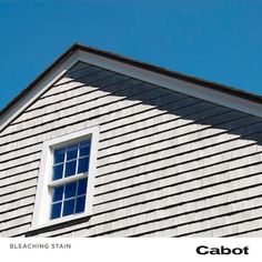 the side of a house with a blue sky in the background and an image of a window