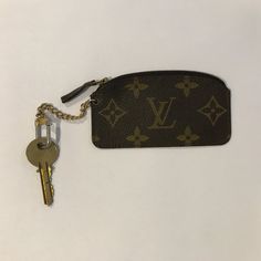 a key chain is attached to a louis vuitton wallet