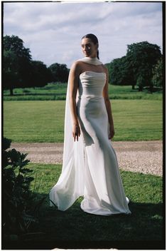 a woman in a white wedding dress posing for the camera