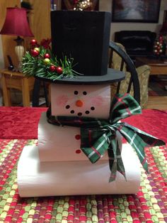 a stack of folded paper with a snowman on top and a hat on top