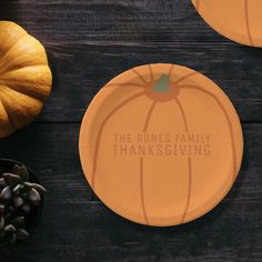 two paper plates with the words, the bones family thanksgiving written on them next to pumpkins