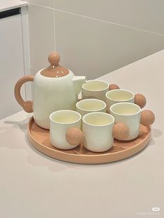 a tray with cups and a tea pot on it