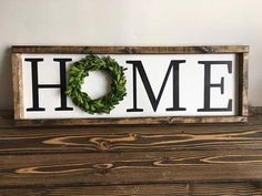 a wooden sign that says home with a wreath on it