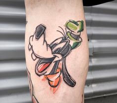 a tattoo on the leg of a person with an orange and green flower in it