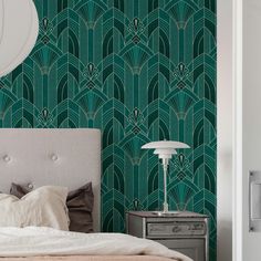 a bedroom with green art deco wallpaper and a white lamp next to the bed