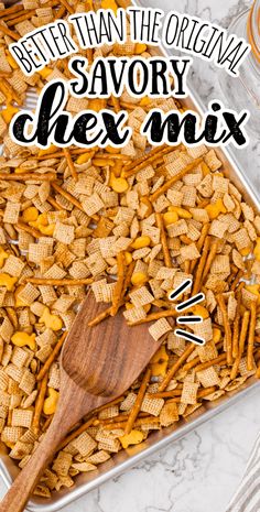 a tray filled with chex mix on top of a table next to a wooden spoon