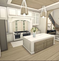 a white kitchen with an island in the middle and stairs leading up to the second floor