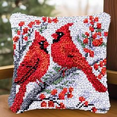 a decorative pillow with two red birds on it