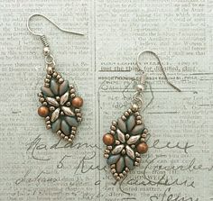 two pairs of earrings sitting on top of a piece of paper