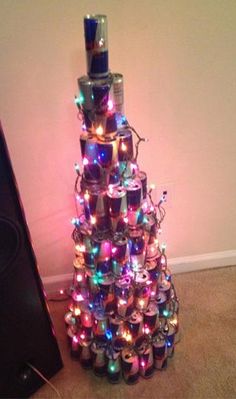 a christmas tree made out of cans with lights on it and speakers in the background