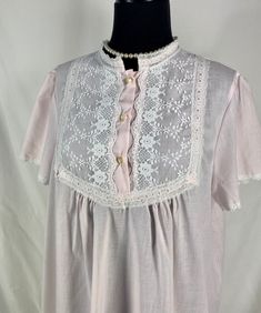 "~ Cute short sleeved Lewis Frimel nightgown in a pretty pale pink ~ Lace details at collar lined with fabric ~ Lace trim at sleeve cuffs ~ Three plastic buttons at chest ~ Made in USA CIRCA: 1980's MATERIALS: No label, probably a cotton/poly blend LABEL: Lewis Frimel CONDITION: Very good - no rips or holes.   MEASUREMENTS:  Vintage sizes are NOT the same as modern sizes.  Please go by the given measurements for a garment and not any listed size when determining fit! ~ No Size tag Shoulder ~ 15.5\" Sleeve ~ 8\" Bust ~ 44\" Length ~ 39\" shoulder to hem At this time I CANNOT ship internationally. I can only ship to US addresses. Excessive shipping charges will be refunded. PLEASE convo me if you have any further questions about this item or would like to see more pictures.  I try to be as a Feminine Lace Trim Nightgown For Sleepovers, Elegant Short Sleeve Nightgown For Bedtime, Feminine White Nightgown With Short Sleeves, White Short Sleeve Nightgown For Pajama Party, Short Sleeve Lace Trim Sleepwear For Home, Spring Short Sleeve Nightgown For Sleepovers, Spring Nightgown For Pajama Party With Short Sleeves, Spring Short Sleeve Nightgown For Pajama Party, Pink Short Sleeve Sleepwear For Spring