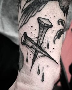 a man's arm with a cross on it and drops of water coming out of it