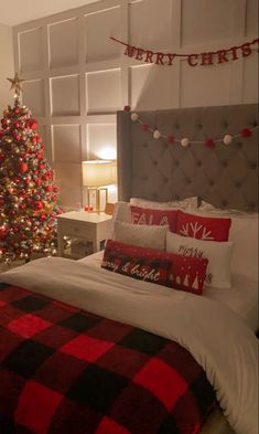 a bedroom decorated for christmas with a tree and lights on the wall behind the bed