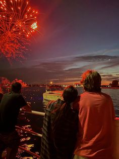 people watching fireworks on the water at night