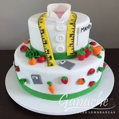 a white cake decorated with fruit and measuring tape