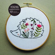 a hedgehog is surrounded by flowers and leaves on a white background with the words hedgehog embroidery