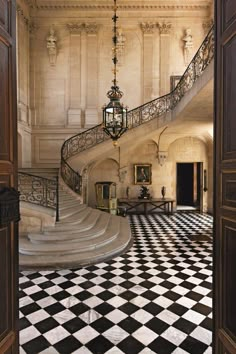 an ornate staircase with black and white checkered flooring