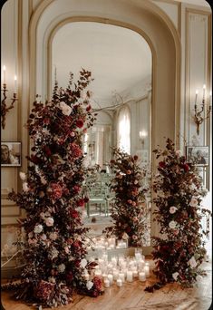 candles and flowers are arranged on the floor in front of an ornate arch with mirrors