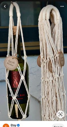 a bottle of wine is hanging from a rope with two corks attached to it