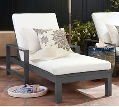 two white chairs sitting next to each other on a patio