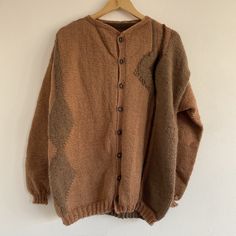 "Vintage 80s Brown Hand Knitted Abstract Button Up Wool Cardigan  Beautiful 1980s geometric patterned cardi! Mid weight, chunky handmade knit. Rusty brown terracotta with beige abstract patterns.  Button down with crew neck collar.  Hippie / cottage / boho style.  Recommended fit: Large / up to UK 16 or over sized on smaller sizes.  In good vintage condition.  Possibly wool & acrylic blend - no care labels. Soft material - not itchy.  See all measurements below. Measurements: Length: 27\" Chest: Oversized Brown Wool Cardigan, Brown Knit Sweater With Buttons, Oversized Brown Buttoned Sweater, Brown Knitted Casual Cardigan, Brown Knit Casual Cardigan, Casual Brown Knitted Cardigan, Cozy Brown Wool Sweater Coat, Brown Wool Cardigan With Chunky Knit, Brown Wool Knitted Cardigan