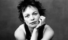 a black and white photo of a woman with her hand on her chin, sitting down