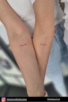 two people holding hands with tattoos on their arms and the words love are written in cursive font